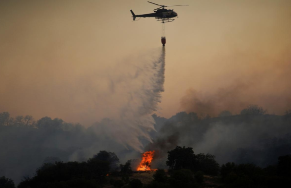 Trực thăng phun nước dập lửa trong đám cháy rừng ở Toledo ngày 28/6. Ảnh: Reuters.