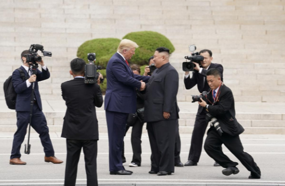 Tổng thống Trump và nhà lãnh đạo Kim Jong-un đã đi về phía nhau từ hai hướng của đường biên giới Hàn-Triều trong cuộc gặp chiều 30/6, bắt tay nhau trước khi ông Kim mời ông Trump bước qua ranh giới phía bắc. Ảnh: Reuters.