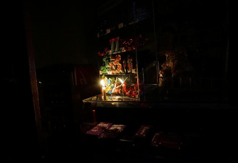 Người dân dùng nến thắp sáng cửa hàng ở Montevideo, Uruguay. Ảnh: Reuters.