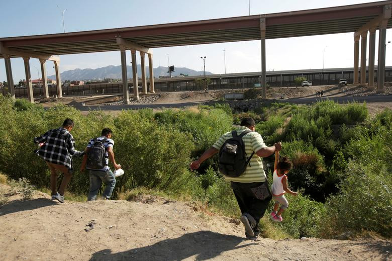 Bức ảnh chụp từ phía Ciudad Juarez (Mexico) cho thấy một số người nhập cư trên bờ sông Ri Grande đang vượt biên trái phép vào Mỹ với mong muốn xin tị nạn tại El Paso, bang Texas, ngày 31/5.