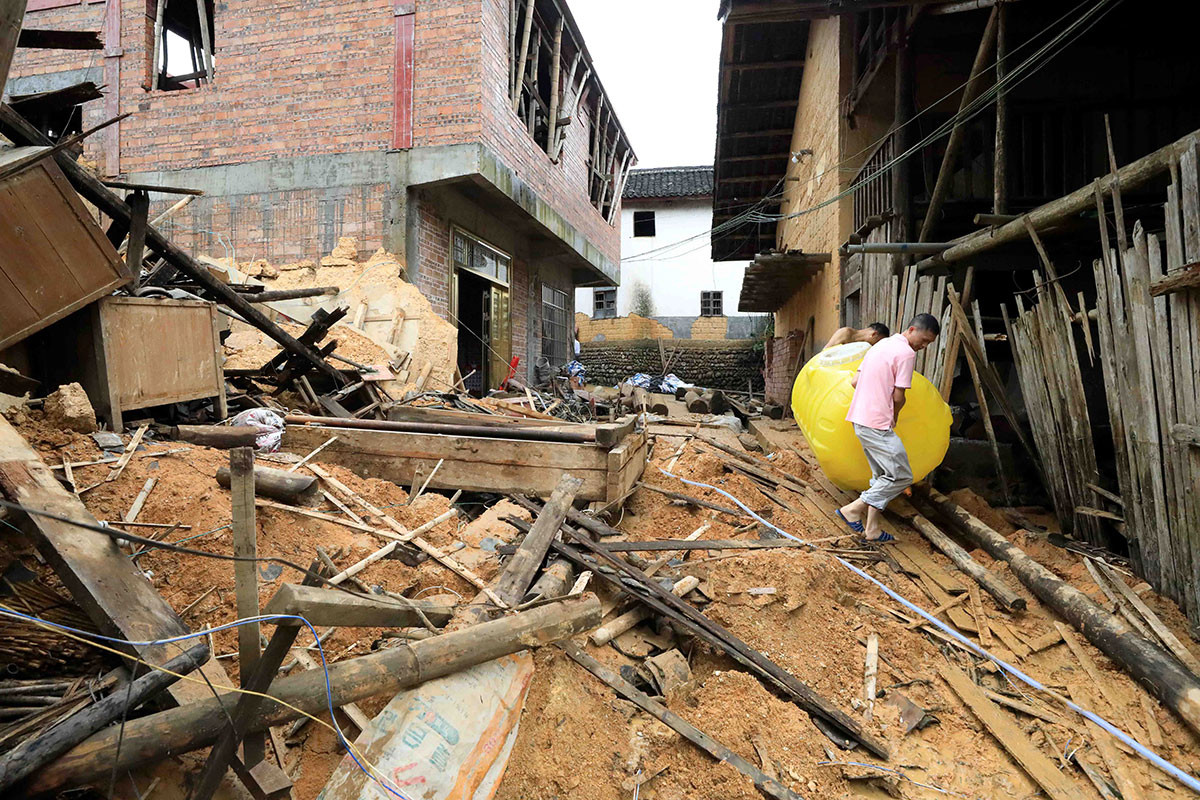 Người dân thu dọn đống đổ nát sau khi ngôi nhà của họ bị lũ lụt tàn phá ở Quảng Tây, Trung Quốc. Ảnh: Reuters.