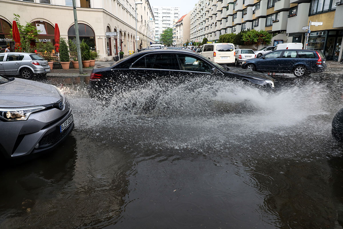Nhiều nơi khác trên thế giới cũng đang chịu ảnh hưởng của điều kiện thời tiết cực đoan. Ảnh: Chiếc ô tô đi qua con đường ngập nước sau một cơn bão mùa hè ở thủ đô Berlin, Đức. Ảnh: EPA.