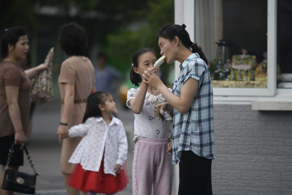 Người phụ nữ ăn kem giải khát trên đường phố Bình Nhưỡng.