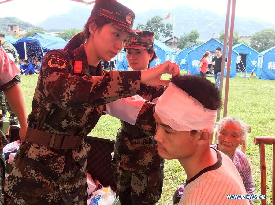 Nữ quân y băng bó vết thương cho một nạn nhân sau trận động đất vừa qua. Ảnh: THX.