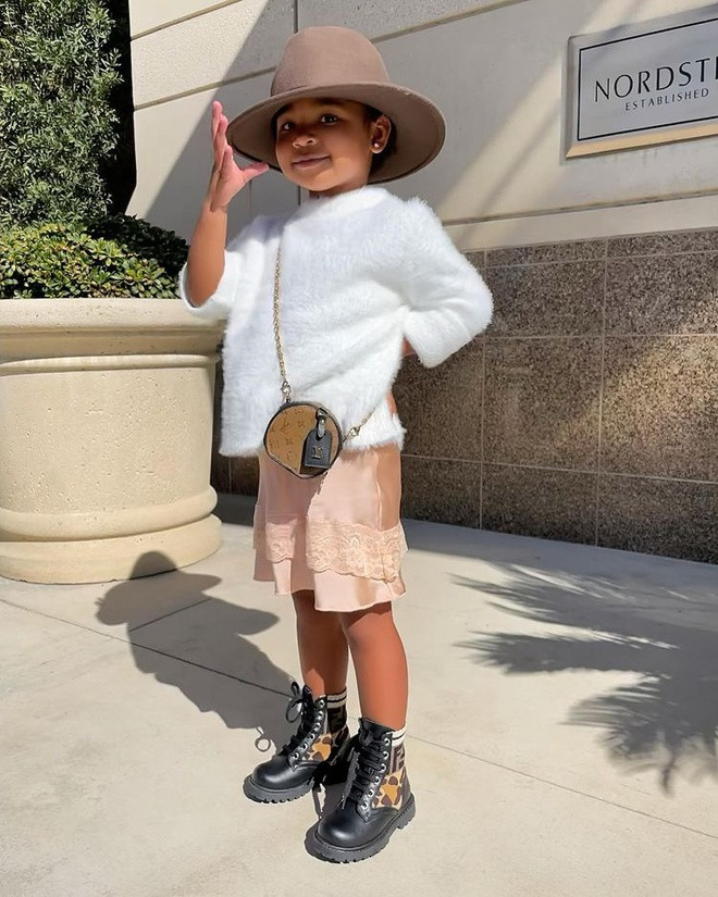 Với chiếc áo lông trắng đáng yêu phối cùng chân váy ngắn, bé True Thompson được mẹ gọi là “fashionista nhí”.