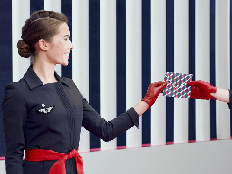 Tuy nhiên, nhà thiết kế Christian Lacroix đã thêm thắt lưng và găng tay màu đỏ tươi vào bộ đồng phục để giúp các tiếp viên nổi bật hơn giữa đám đông.