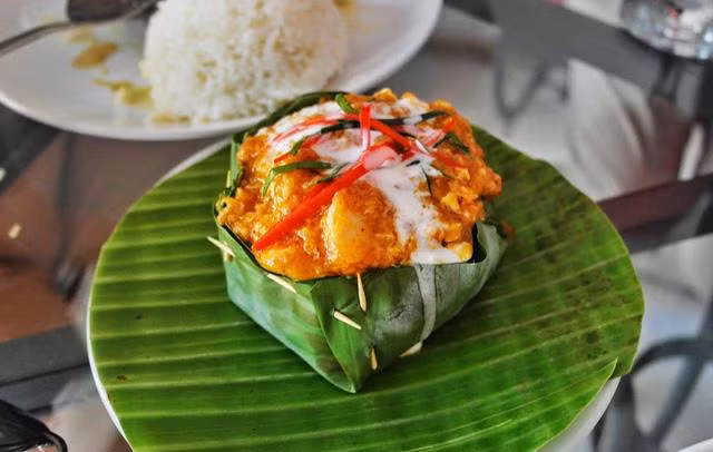  Cá hấp Amok kết hợp nhiều nguyên liệu như cá, đường thốt nốt, nước dừa, và mắm bồ hóc tạo nên một hương vị đặc trưng độc đáo cho món ăn.