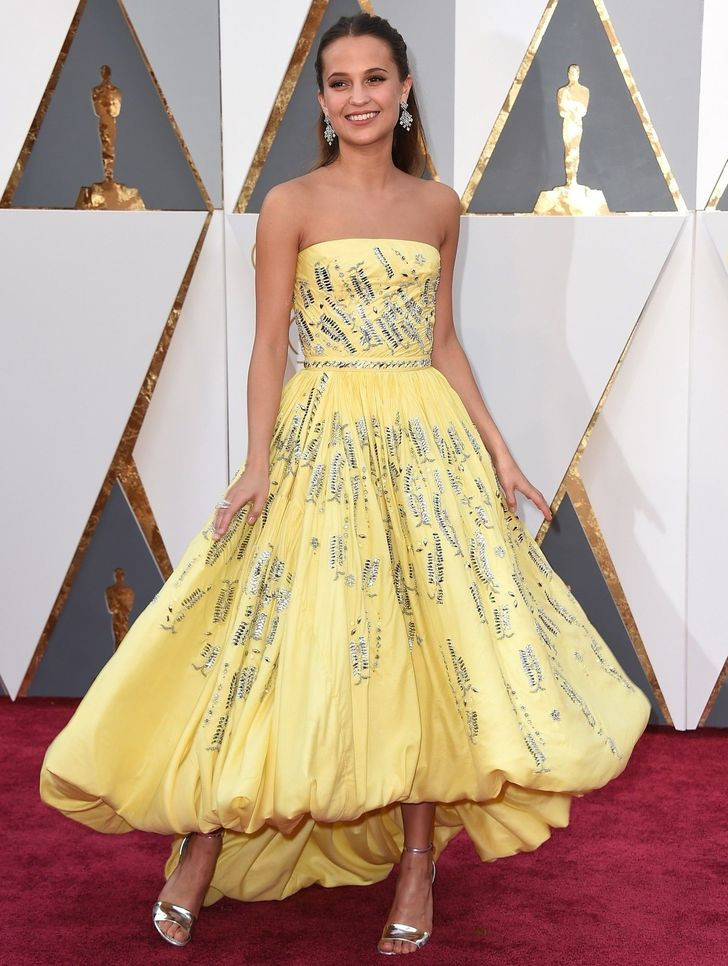 13. Alicia Vikander - 80.000 USD: Alicia có lẽ là người tỏa sáng nhất tại lễ trao giải Oscar 2016. Nữ diễn viên từng được đề cử Oscar khiến người khác choáng váng với chiếc váy quây bất đối xứng màu vàng có thêu kim loại. Chiếc áo này được thiết kế bởi Louis Vuitton và có giá khoảng 80.000 USD.