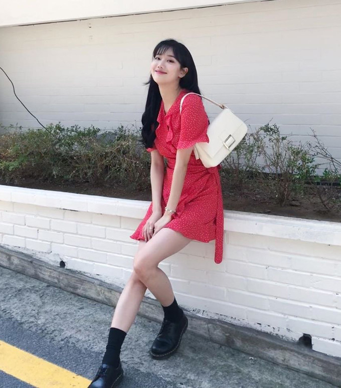 Là một tín đồ phong cách vintage chính hiệu, Na Eun nổi bật trên phố với váy đỏ hoa nhí buộc dây ngang eo đi kèm túi "kẹp nách" và tất cao cổ cá tính. Ảnh: Internet.