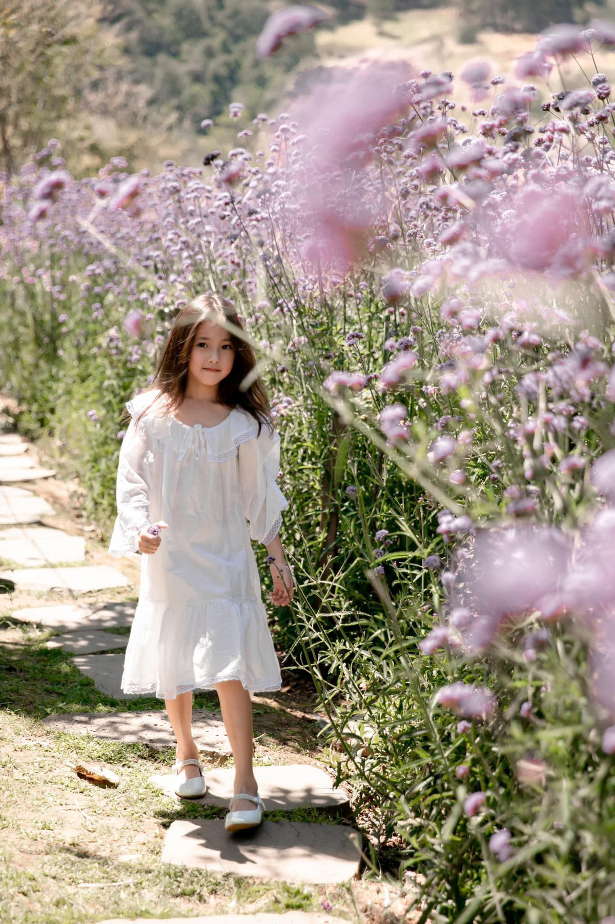 Diện bộ váy trắng tinh khôi giữa vườn hoa, Viann giống như một thiên thần đang dạo chơi.