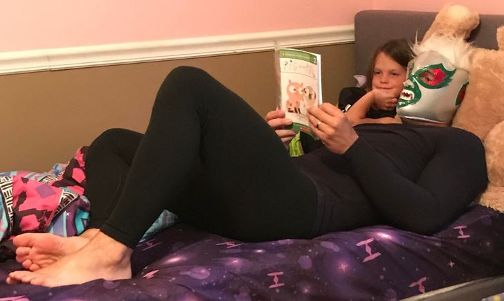 Con gái chăm chú lắng nghe cha đọc truyện.