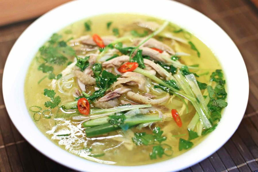 Tiếp tục chần miến rồi gắp ra tô, xếp thịt gà, đầu hành lá, hành tây, rau răm, hành ngò và ớt cắt lát lên trên, chan nước dùng vào, rắc thêm tiêu, dùng nóng. Dọn kèm nước mắm, chanh, ớt và rau thơm.