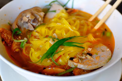 Phần đạm bao gồm sườn lợn, tôm và trứng chim cút. Khi ăn, thực khách cho thêm các loại rau xanh, ớt, chanh và món bánh tráng mè giòn.