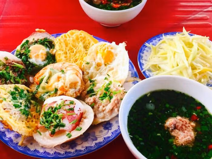 Bánh căn: Bánh căn làm từ bột gạo và nước cốt dừa tươi, được hấp chín cẩn thận trong những chảo đất nung nhỏ trước khi hoàn thiện bằng lớp phủ từ trứng chim cút, thịt lợn băm hoặc tôm, mực.