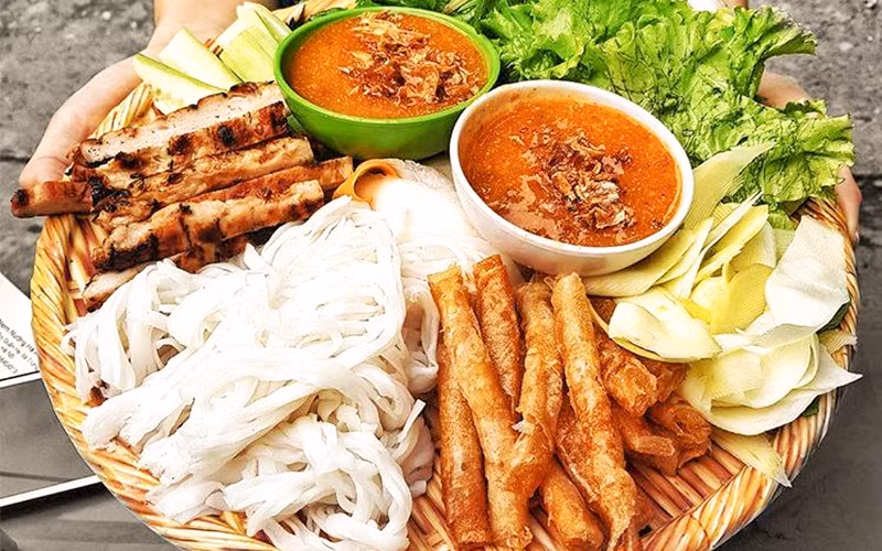 Nem nướng: Món nem nướng ăn kèm các loại rau quen thuộc của Việt Nam như rau diếp cá, húng quế, tần ô, xà lách, cùng với một đĩa kim loại đựng dưa chuột, xoài xanh, gừng mỏng và bánh tráng.