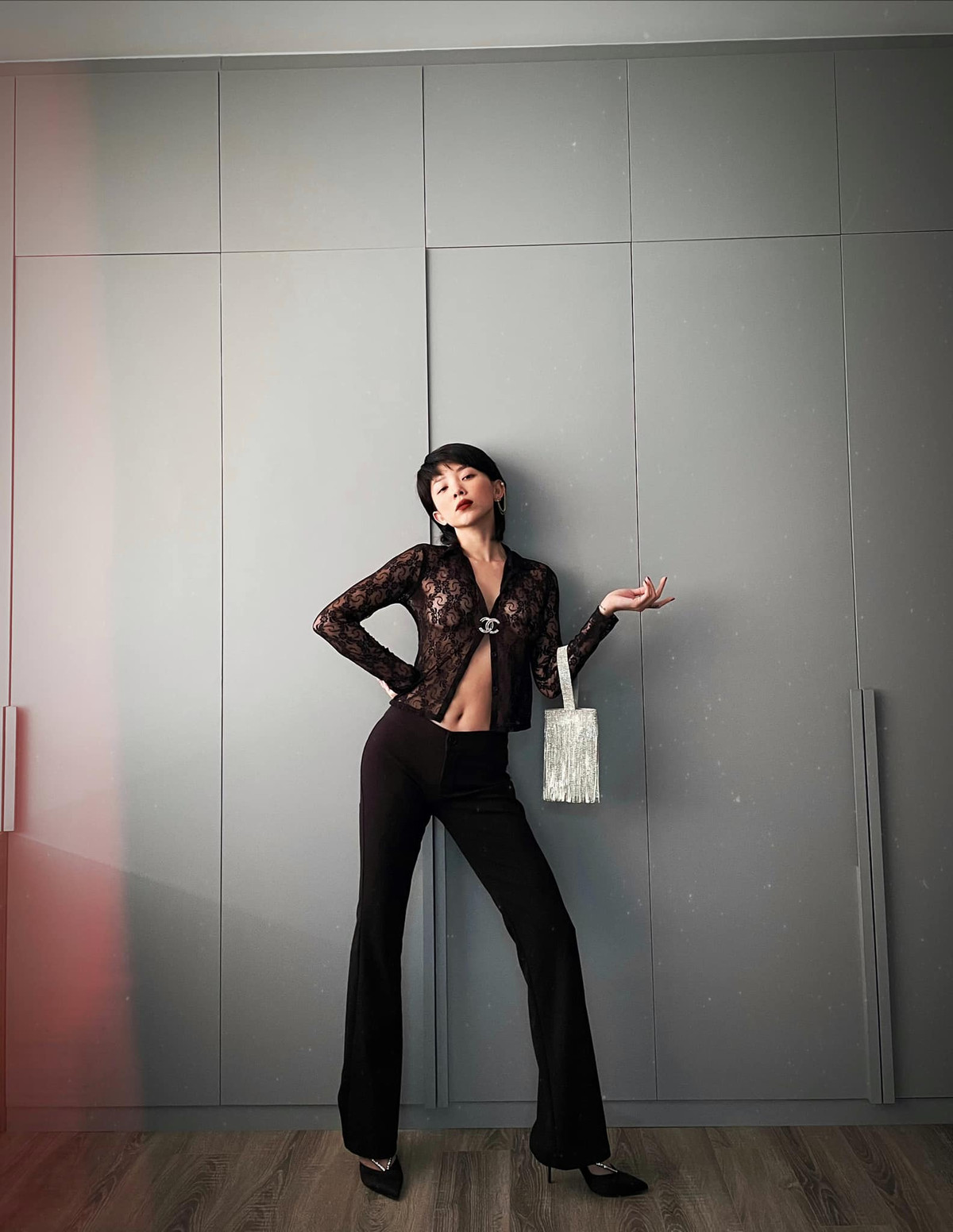 Lần khác, nữ ca sĩ chọn trang phục cực sexy với áo ren xuyên thấu, quần âu ống đứng và túi xách tay tau rua ánh kim.