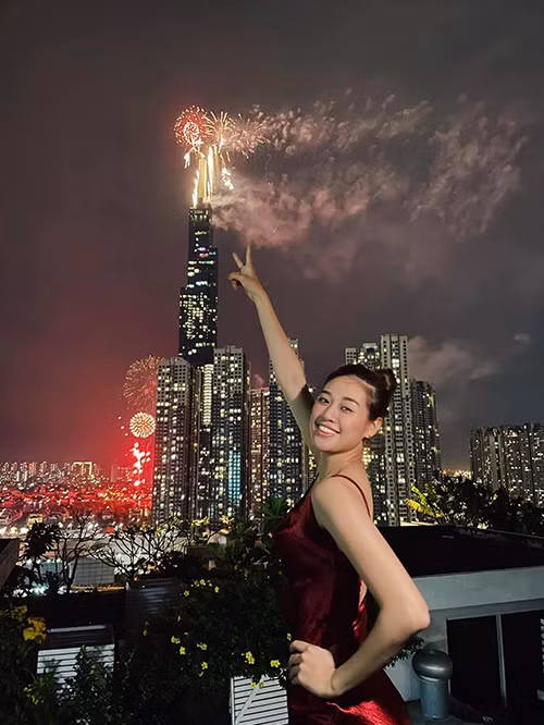 Hoa hậu Khánh Vân khoe nét rạng rỡ với thiết kế váy lụa tông màu đỏ rượu. Trang phục hai dây tôn nét mảnh mai và phù hợp với không khí đón năm mới ấm cúng tại nhà.