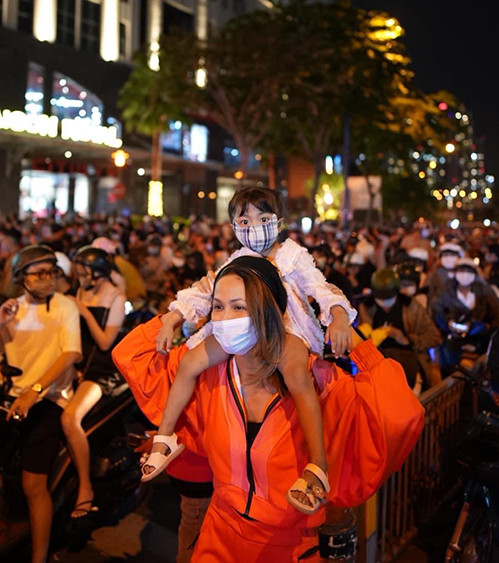 Trong khi đó, hoa hậu H'Hen Niê chọn trang phục thể thao với tông cam bắt mắt khi hoà cùng dòng người đi ngắm pháo hoa.