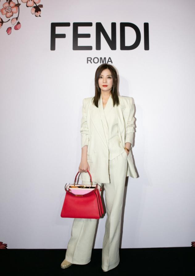 Bộ suit trắng phối cùng túi xách đỏ mang đến vẻ sang chảnh, quý phái cho mỹ nhân U50.