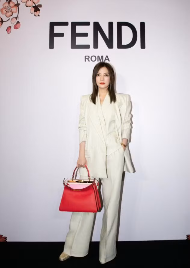 Bộ suit trắng phối cùng túi xách đỏ mang đến vẻ sang chảnh, quý phái cho mỹ nhân U50.