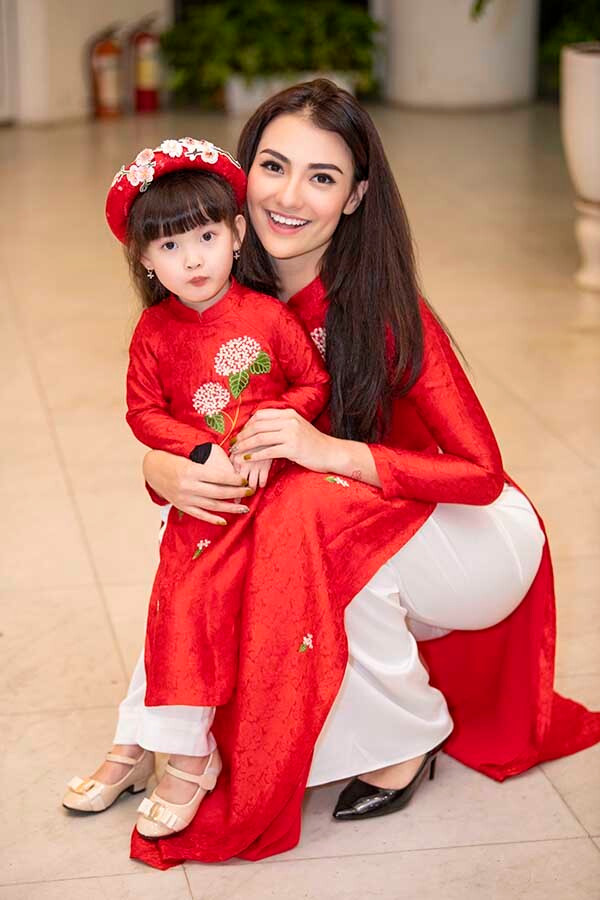 Mẹ con Hồng Quế diện áo dài đôi màu đỏ, điểm nhấn là họa tiết thêu ở ngực, eo.