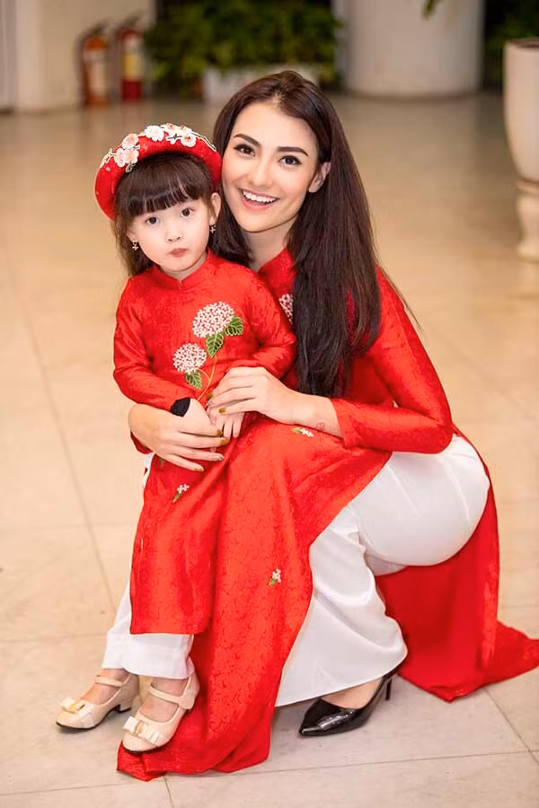 Mẹ con Hồng Quế diện áo dài đôi màu đỏ, điểm nhấn là họa tiết thêu ở ngực, eo.