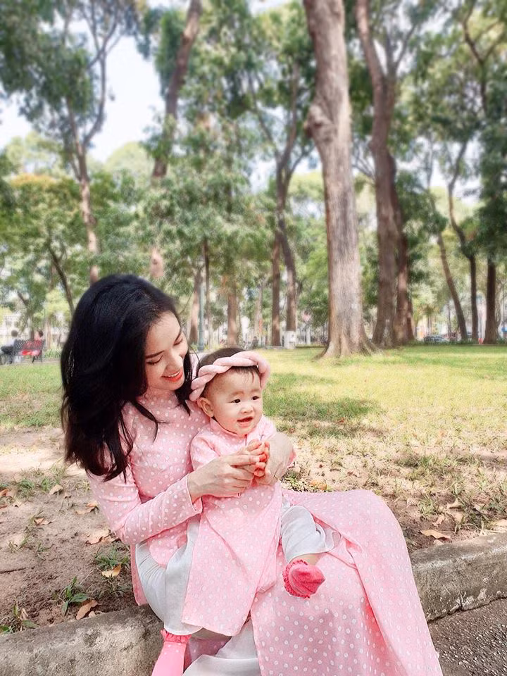 Nữ diễn viên Tú Vi và con gái diện áo dài đôi với họa tiết chấm bi nữ tính trên nền vải lụa sắc hồng pastel.