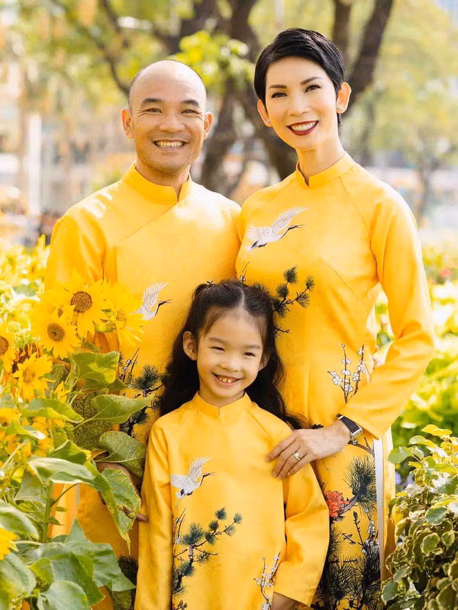 Hòa chung không khí Tết cùng mọi người, cựu người mẫu Xuân Lan mặc đồng phục áo dài vàng khoe vẻ đằm thắm bên con gái nhỏ và chồng.