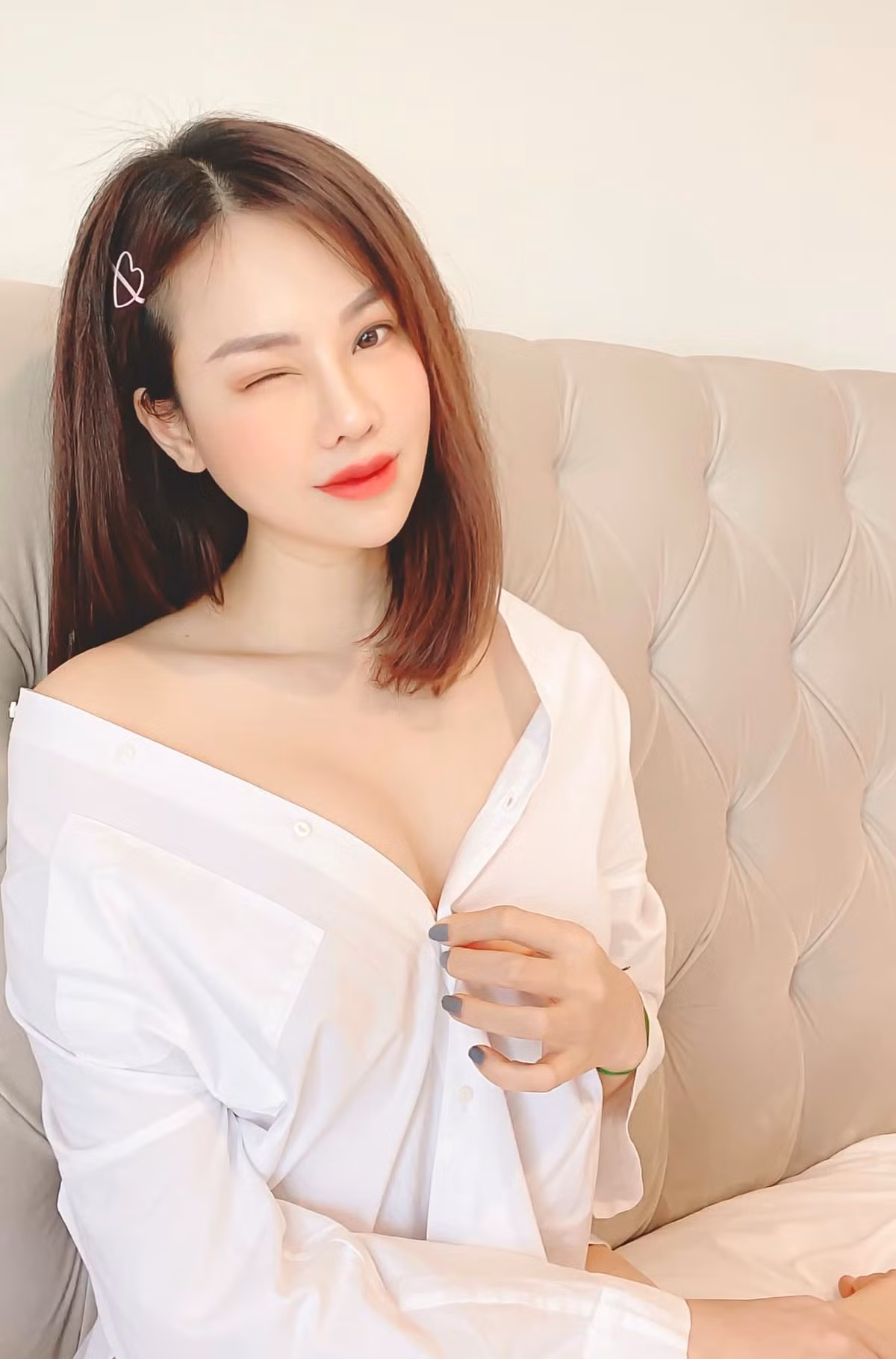 Người đẹp tự tin khoe bờ vai nõn nà cùng vòng một lấp ló trong chiếc áo sơ mi trắng bung cúc.