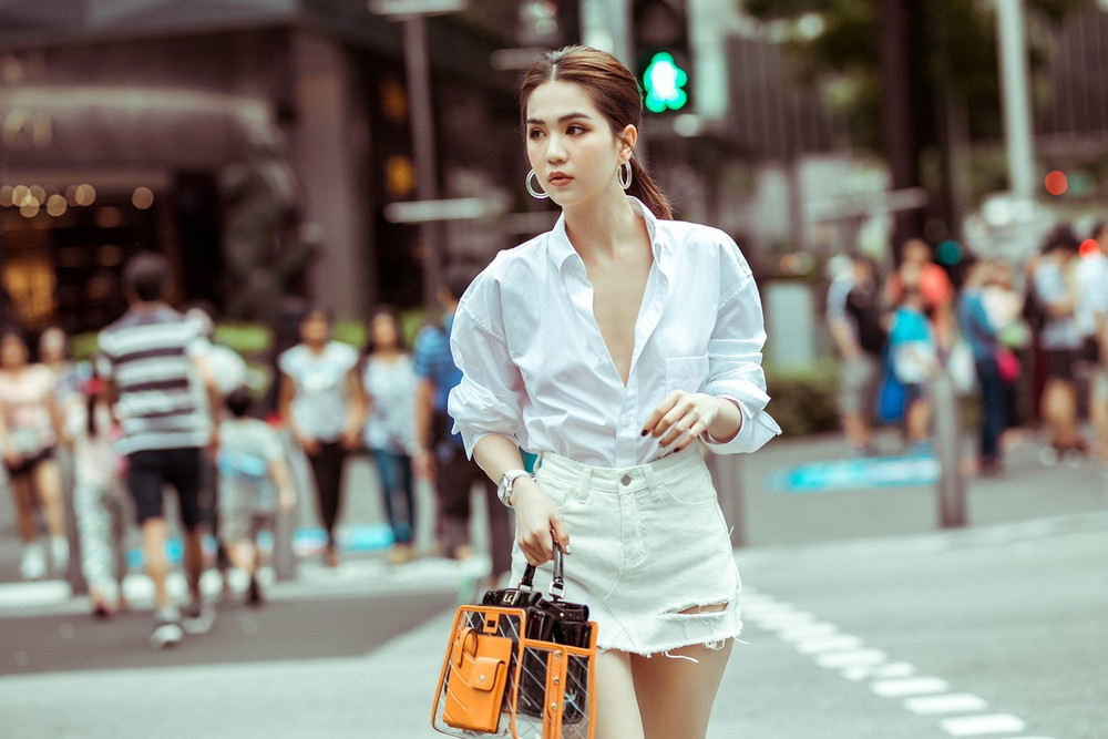 Mặc áo sơ mi trắng ngoan hiền nhưng Ngọc Trinh lại phanh cúc ngực sexy hết cỡ.