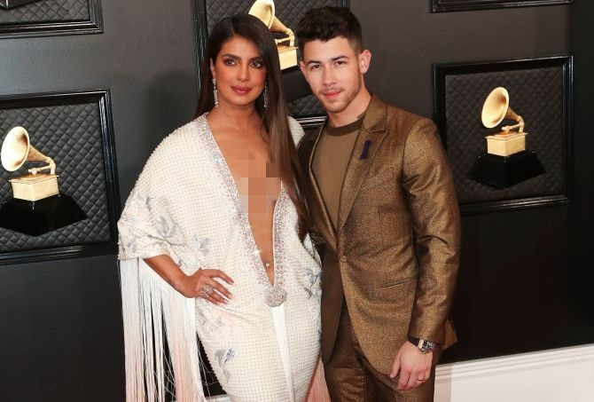Priyanka Chopra rạng rỡ sánh vai bên chồng trẻ Nick Jonas nhưng bộ đầm của cô trở thành tâm điểm tranh cãi tại thảm đỏ Grammy 2020. Thiết kế có phần cổ áo xẻ sâu đến tận rốn, dáng váy đuôi cá và đính kết dây tua rua ở thân áo trên.