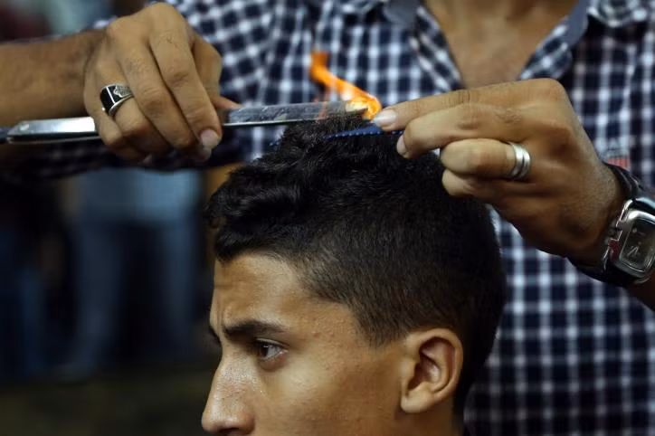 Một lúc sau, người thợ lại một lần nữa rắc bột, đốt tóc thêm lần nữa và dùng lược hoàn thành "tác phẩm" của mình.