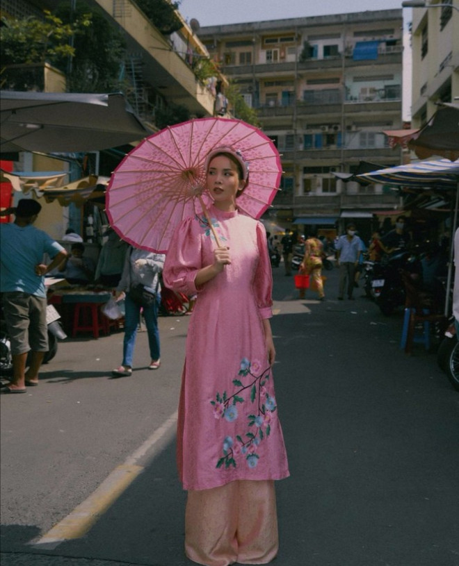 Yến Trang dịu dàng với áo dài gấm màu hồng phấn tay bồng, thêu hoa văn đẹp mắt.