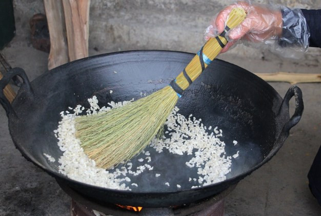 Sau đó mang gạo đi ngâm khoảng 2 tiếng rồi vớt ra. Lúc này người làm Khẩu sli sẽ lấy bột ngô tẻ hoặc gạo tẻ trộn vào gạo đã ráo nước trước khi cho vào chõ để đồ xôi. Việc này sẽ giúp các hạt xôi không bị bết dính vào nhau. Trong lúc đồ xôi phải canh để hạt gạo vừa chín tới thì bỏ ra, quá lửa xôi sẽ ướt không làm được bánh. Xôi đồ xong được cho ra cán tơi từng hạt.