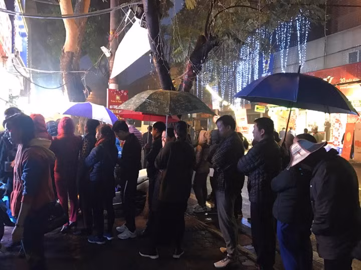 Xếp hàng xuống tận vỉa hè dù thời mưa.