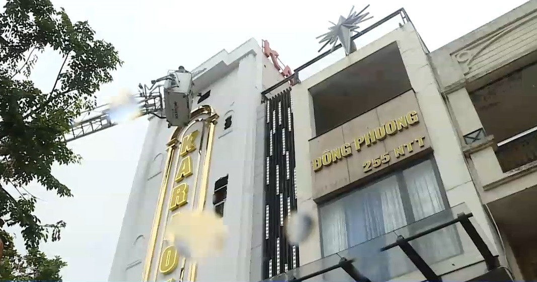 Lực lượng chữa cháy dùng xe thang đục mặt dựng alu đặt bảng quảng cáo ở phía trước quán để phun nước từ bên ngoài vào.