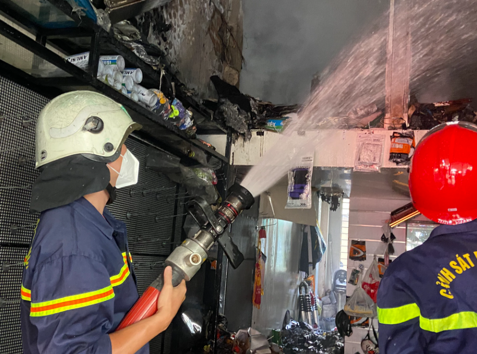 Lực lượng chữa cháy phun nước từ tầng 1 để khống chế ngọn lửa.