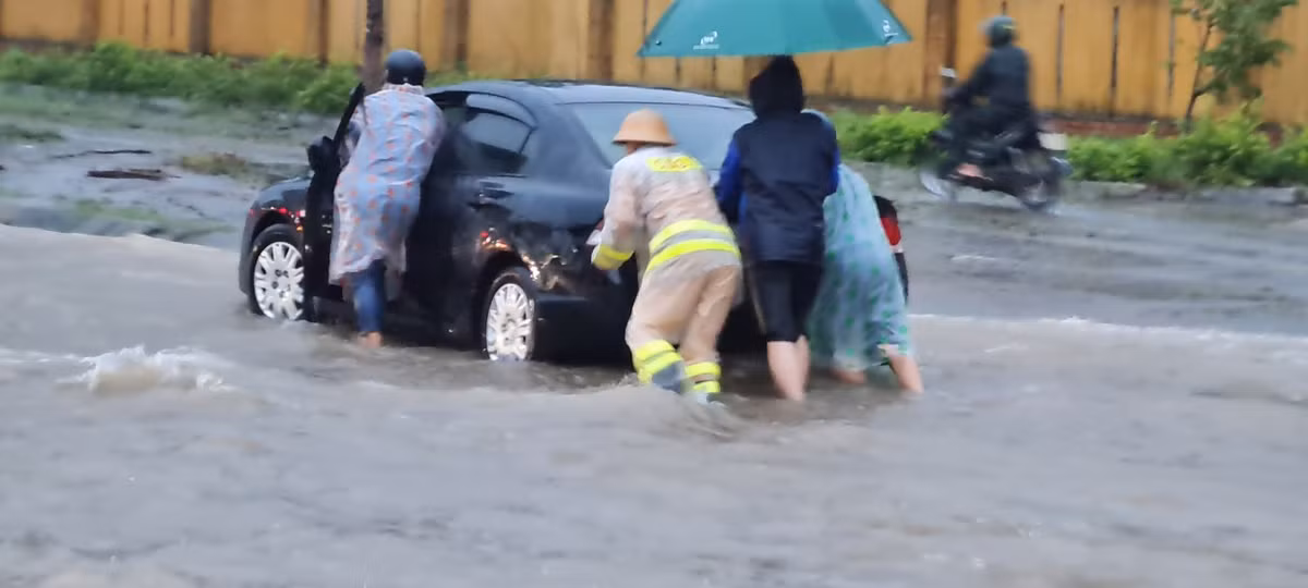 Cảnh sát giao thông hỗ trợ đẩy xe qua đoạn đường bị ngập.