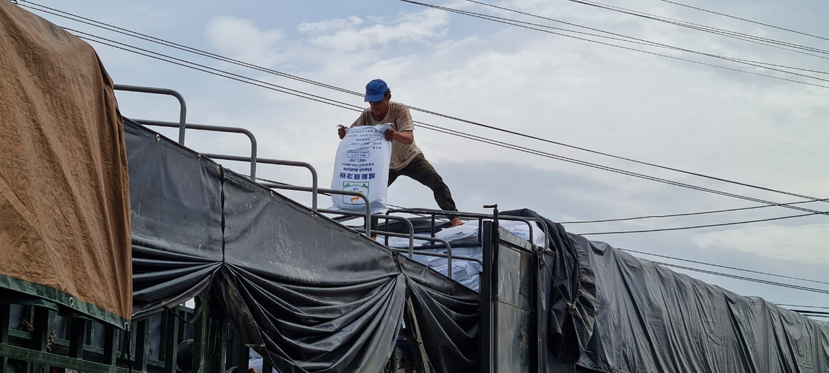 Hàng hóa trong xe tải đang được bốc xếp sang xe khác.