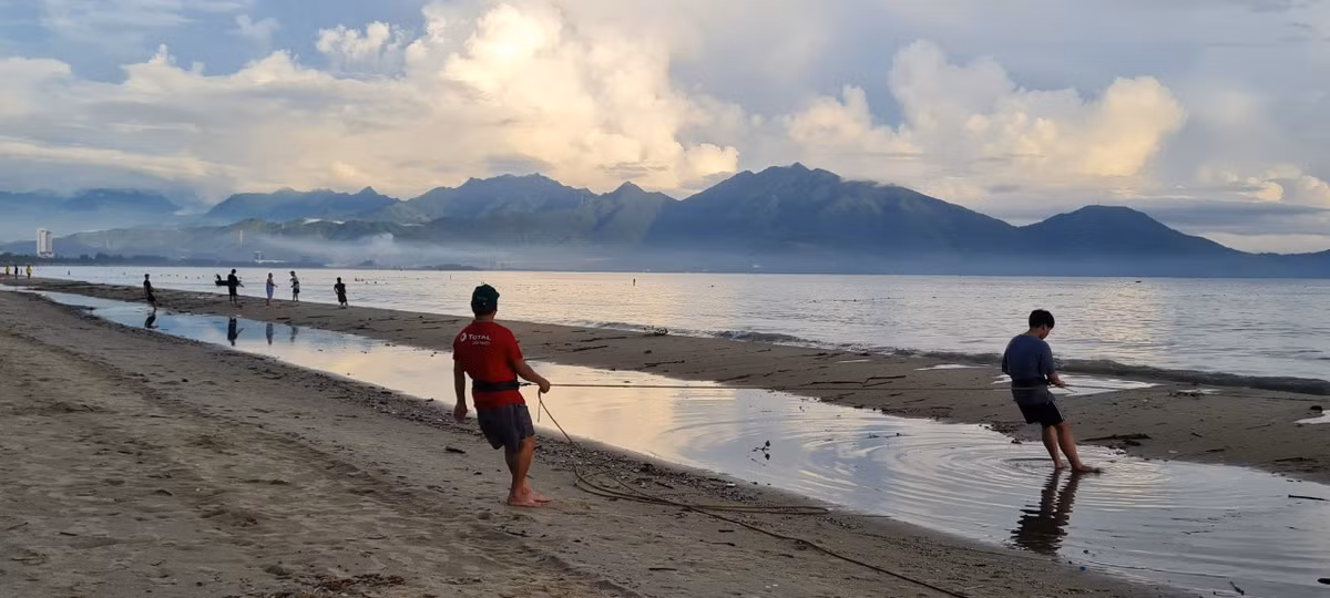 Hàng chục người, cả nam lẫn nữ đang tập trung kéo lưới.