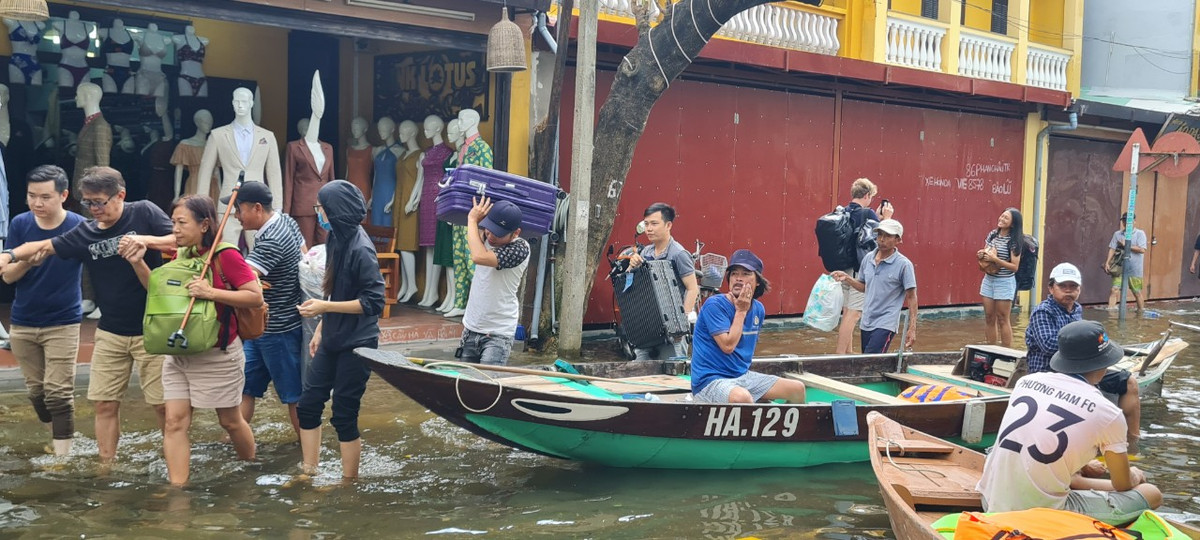 Khách du lịch được hỗ trợ di chuyển đồ đạc đến nơi cao hơn.