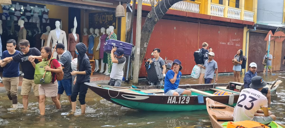 Khách du lịch được hỗ trợ di chuyển đồ đạc đến nơi cao hơn.