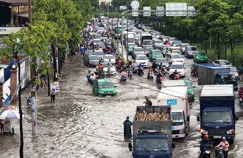 Hàng nghìn phương tiện bì bõm lội qua "rốn ngập" Nguyễn Hữu Cảnh trong cơn mưa chiều 7/5 vừa qua.