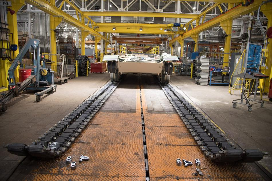 Công việc này đòi hỏi độ chính xác cao và thao tác giữa nhiều thợ lắp ráp phải chuẩn xác để cả hai bên xích của xe tăng đều được khớp vào vị trí cùng lúc. Nguồn ảnh: Sina.