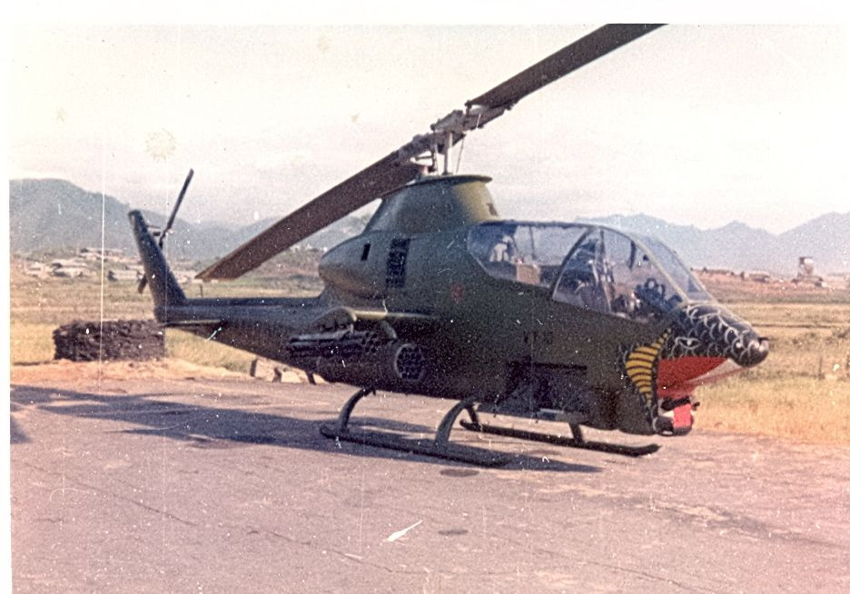 Với hoả lực chính của AH-1 Cobra đặt dưới hai cánh treo hoả lực của máy bay, cấu hình vũ khí sẽ bao gồm 1 bệ phóng pháo phản lực cỡ 70mm cùng 1 khẩu 6 nòng M134 với 1500 viên đạn ở mỗi bên. Hệ thống vũ khí này do phi công lái chính của AH-1 ngồi ở ghế lái số hai điều khiển. Nguồn ảnh: Pinterest.