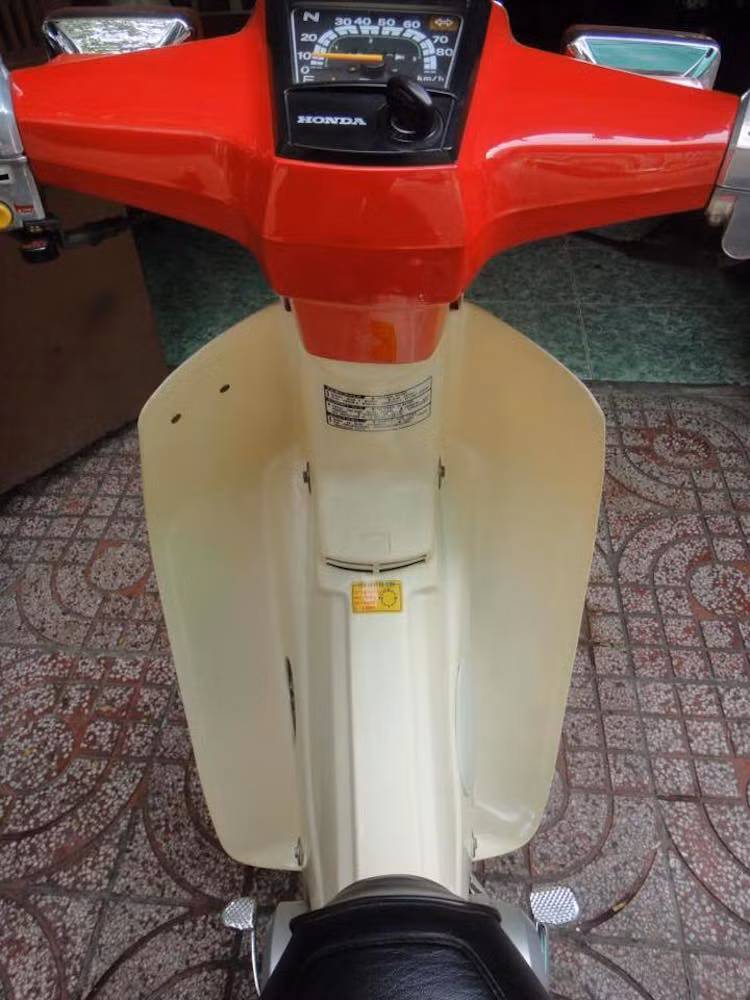 DD cũng được lắp yếm có màu ngà đặc trưng, cùng bảng đồng hồ hình thang tích hợp ổ khóa. So với Super Cub C70, chiếc xe còn có mặt bảng đồng hồ thiết kế khác và tem dán giấy, thay vì có logo nổi hai bên nắp che thân xe.