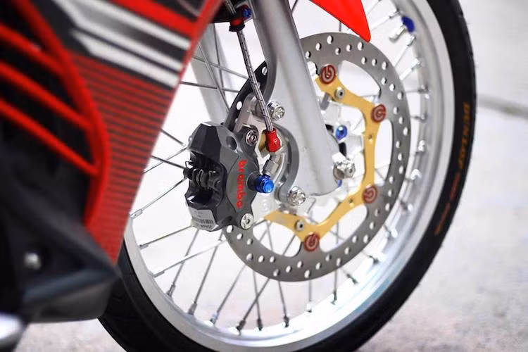 Cặp mâm đúc nguyên bản của Exciter 135 đã được chủ xe thay bằng niềng nhôm Excel nhẹ và sắc sảo hơn. Điểm nhấn thực sự ở "dàn chân" trước của xe nằm ở hệ thống phanh khá "khủng" với heo Brembo Billet 2 piston đối xứng kèm pad nhôm CNC và đĩa Brembo full-floating.