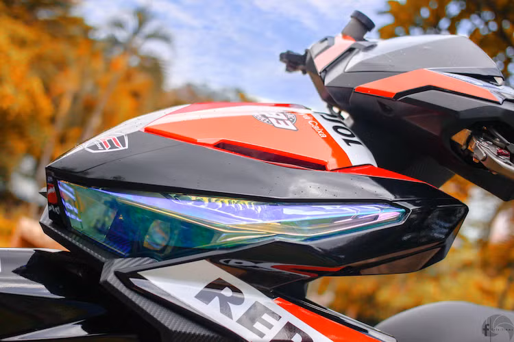 Toàn bộ dàn áo của chiếc xe cũng đã được trang trí lại với tem đấu Repsol đặc trưng của hãng xe máy Honda với 4 màu đen - cam - đỏ - trắng sặc sỡ. Chóa đèn trước của xe cũng đã được phủ pha lê đổi màu đẹp mắt.