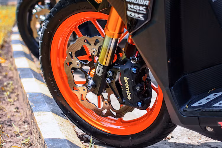 Trong đó, "dàn chân" trước của xe đã được chủ nhân đầu tư khá kỹ càng với cặp phuộc USD Ohlins, phanh Brembo lấy từ xe PKL với pát bắt dọc và đĩa kiểng Galfer. Bộ mâm 5 cánh nguyên bản của Vario được sơn lại trong màu cam nổi bật.