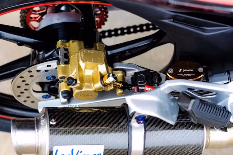 Bên cạnh côn tự động, hệ thống phanh sau của Exciter đời đầu cũng chỉ là phanh đùm đơn giản. Chính vì vậy, chủ xe cũng đã nâng cấp hệ thống phanh với heo và pen đạp Nissin cùng đĩa Yamaha Z125, bình dầu Rizoma và dây dầu Galfer. Cây pô Leovince carbon với cổ pô full cũng phô diễn hiệu quả hơn tiếng máy đã được "chọt" của xe.